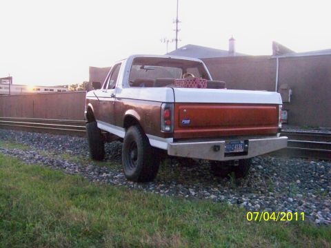 1989 Ford Bronco - This 1989 Ford Bronco, seen from the rear, is parked next to railroad tracks with a custom bumper.