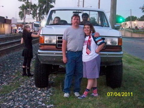 1989 Ford Bronco - A family poses in front of a lifted white Ford Bronco on a sunny day.