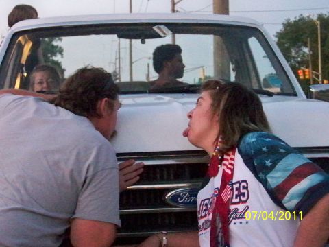 1989 Ford Bronco - Two people interact with the grille of a 1989 Ford Bronco. The date 07/04/2011 is visible.