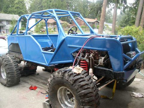 1979 Ford Bronco - This heavily modified off-road buggy features a custom blue roll cage and oversized tires, suggesting it's built for extreme terrain.