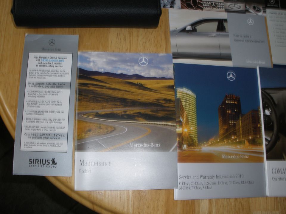Mercedes-Benz owner's manuals and Sirius Satellite Radio information booklet on a wooden surface