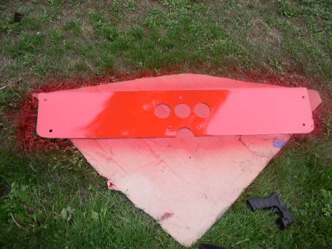 1979 Ford Bronco - Metal panel being painted red, laid out on cardboard in the grass.