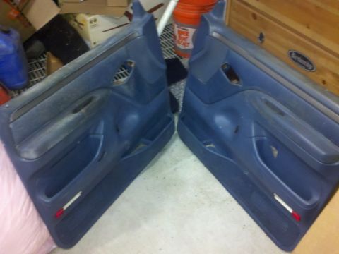 2005 Ford F-250 - Two blue truck door panels are shown, likely for a Ford F-250, with storage pockets and reflectors.