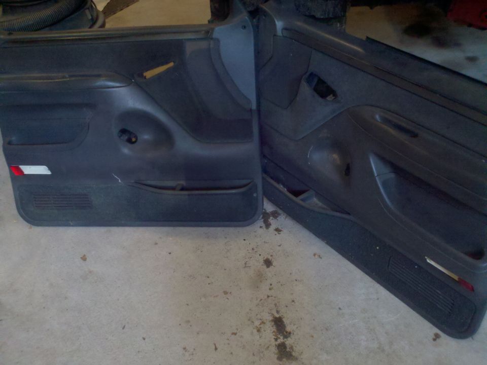 Two dark gray truck door panels, one with a red reflector strip
