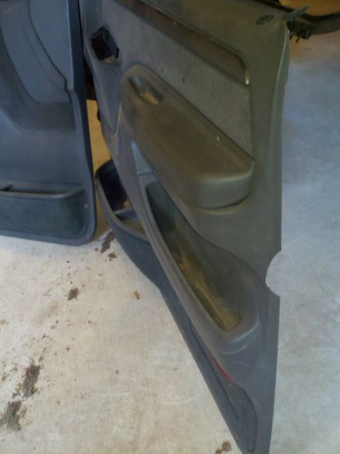 2005 Ford F-250 - A detached car door panel is shown, revealing its interior construction and storage features.