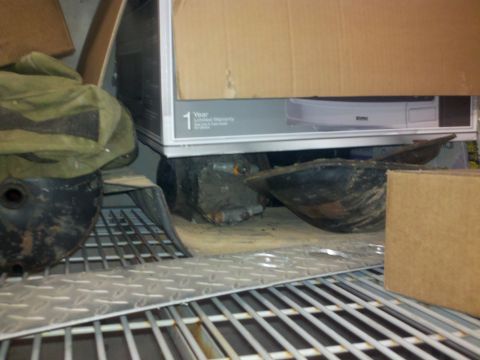 2005 Ford F-250 - Several vehicle parts are visible on metal shelving units, alongside cardboard boxes.