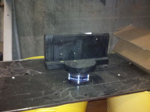 2005 Ford F-250 - A black plastic component with a clear base sits on a dark surface, with a cardboard box nearby.