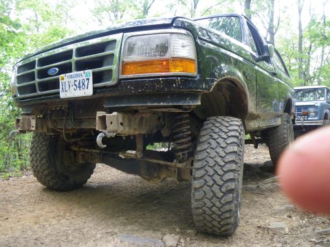 1995 Ford Bronco - This 1995 Ford Bronco is equipped with off-road tires and is seen on a trail with another vehicle in the background.