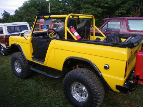 1995 Ford Bronco - This yellow Ford Bronco, likely from the late 1970s, is seen at an outdoor event.