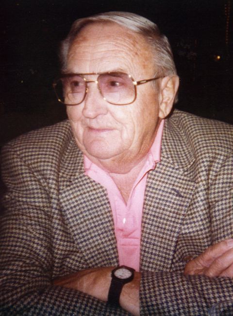 1968 Ford Mustang - A close-up shot of an older gentleman with glasses, dressed in a pink shirt and a houndstooth jacket.