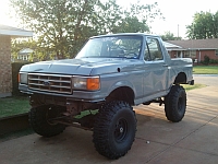 1986 Ford Bronco - This lifted 1987 Ford Bronco is shown in a 3/4 front view, parked in a driveway.