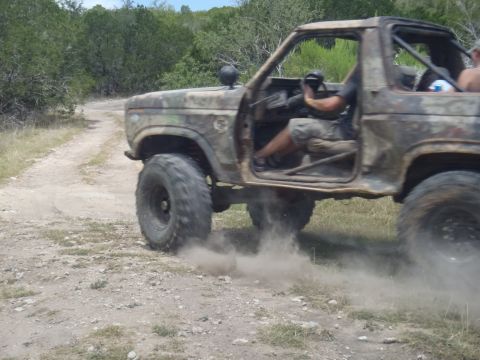 1979 Ford Bronco - This vehicle is kicking up dust as it drives on a dirt road.