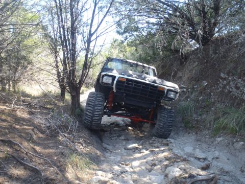 1979 Ford Bronco - A modified 1979 Ford Bronco navigates a challenging, rocky off-road path.
