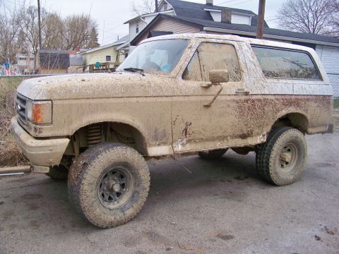 1989 Ford Bronco - This 1989 Ford Bronco is heavily covered in mud, obscuring much of its original appearance.