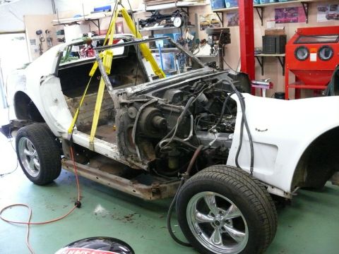 1976 Chevrolet Corvette - This car is in a workshop and appears to be undergoing repairs or restoration, with its body lifted for access.