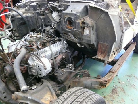 1976 Chevrolet Corvette - The engine bay of a 1976 Chevrolet Corvette shows its carburetor, alternator, and exposed chassis components.