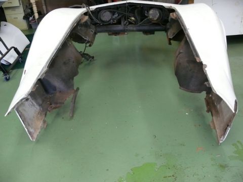 1976 Chevrolet Corvette - Front clip of a car, likely a Corvette, showing exposed engine and damaged fender areas.