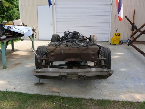 1976 Chevrolet Corvette - The frame of a 1976 Chevrolet Corvette is shown with the engine and wheels attached.