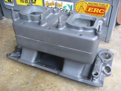 1953 Ford Mainline - A gray Edelbrock intake manifold sits on a concrete floor, with stickers visible in the background.