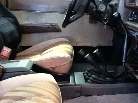 1988 Suzuki Samurai - Interior view of a 1988 Suzuki Samurai, highlighting the seats and dual gear shifters.