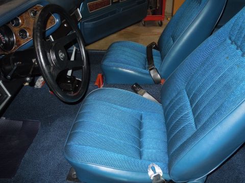1972 Chevrolet Camaro - The interior of a 1972 Chevrolet Camaro features blue patterned bucket seats and a woodgrain dashboard panel.