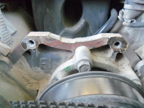 2000 Mercury Grand Marquis - Brake caliper bracket showing wear and rust, with associated brake rotor and belt.