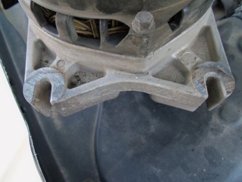 2000 Mercury Grand Marquis - A close-up view of an alternator mounting bracket, showing its metallic construction and internal wiring.