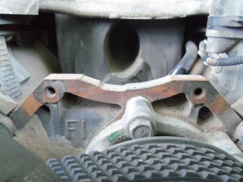 2000 Mercury Grand Marquis - A close-up view of a vehicle's engine component, showing some stamped markings and a ribbed belt.