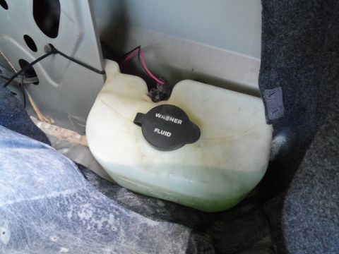 2000 Mercury Grand Marquis - The washer fluid reservoir is visible in the trunk area of a vehicle.