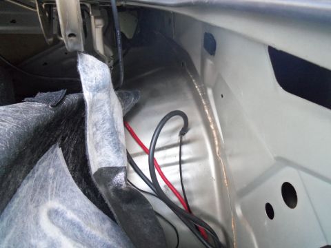 2000 Mercury Grand Marquis - A view inside the trunk of a car, revealing wiring and sound dampening material.