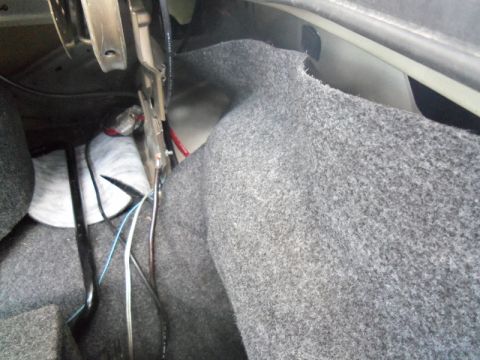 2000 Mercury Grand Marquis - The interior of a car trunk shows gray carpeting and visible wiring, with no clear year identification.