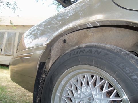 2000 Mercury Grand Marquis - The rear wheel well of a car is shown, with a tire and part of the fender visible.