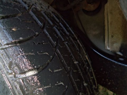 2000 Mercury Grand Marquis - Close-up view of a tire's tread pattern, showing wet surface and water droplets.