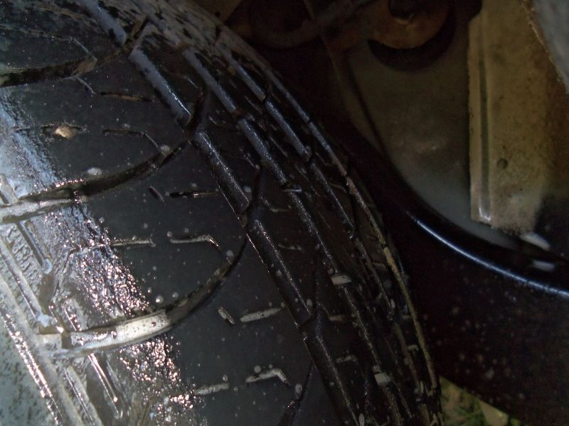 Close-up of a wet tire tread with visible water droplets