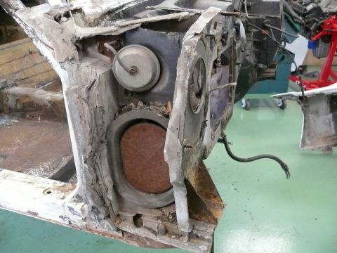 1976 Chevrolet Corvette - This image shows a damaged chassis component, possibly from a Corvette, with a rusted circular element and a detached brake line visible.