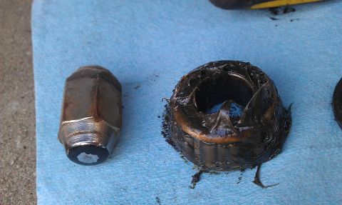 1992 Ford Ranger - A lug nut and a wheel bearing packed with old grease are shown on a blue shop towel.