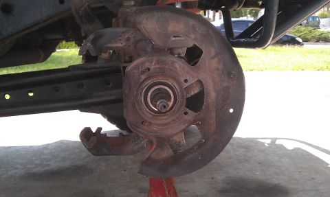 1992 Ford Ranger - Close-up of a heavily rusted brake rotor and hub assembly, indicating wear and tear on the vehicle's suspension system.