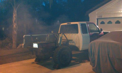 1992 Ford Ranger - Customized 1992 Ford Ranger pickup truck with a roll cage and oversized tires is parked outside a garage.