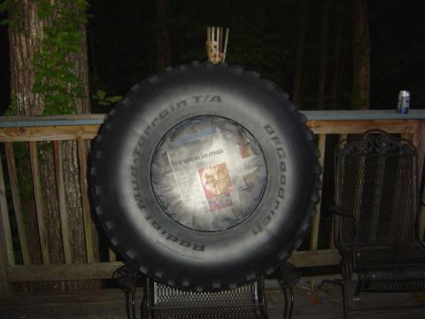 1986 Ford Bronco - Spare tire on display with newspaper showing 'New spin on ice cream' headline.