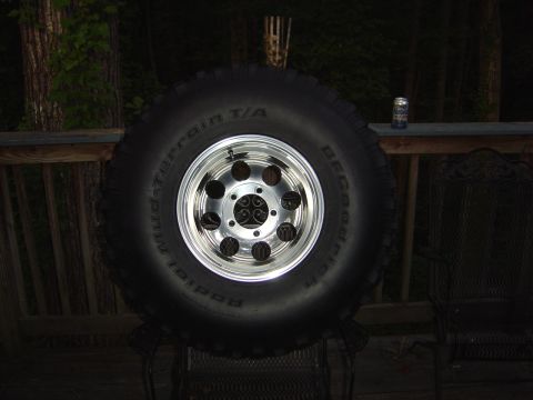1986 Ford Bronco - A spare tire and wheel assembly is shown mounted on a wooden deck railing.