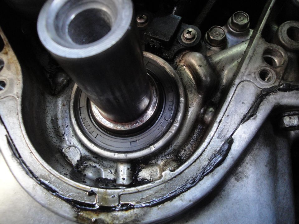 Close-up of a greasy engine component with a bearing and metal shaft