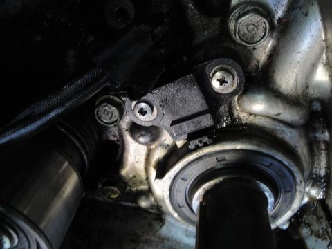 1993 Ford Taurus - Close-up view of an engine component, likely a sensor and a seal, with visible bolts and wiring.