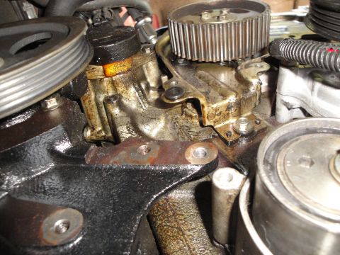 1993 Ford Taurus - Engine part with Ford logo, likely a pump or sensor, covered in oil.