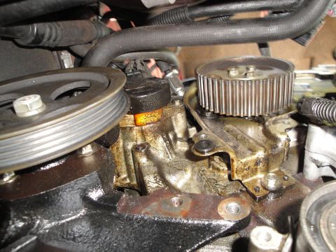 1993 Ford Taurus - A close-up view of engine components, showing a pulley and a timing gear with a visible Ford logo.