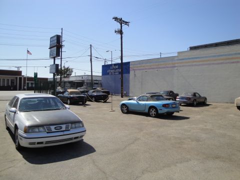 1993 Ford Taurus - A white 1993 Ford Taurus is parked in a lot with several other vehicles.