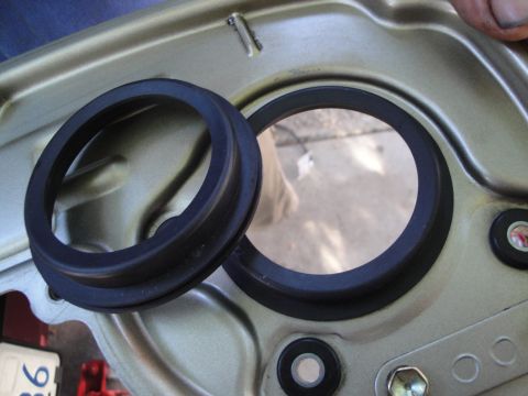 1993 Ford Taurus - A rubber seal is shown next to its corresponding housing, with a partial part number visible on a white label.