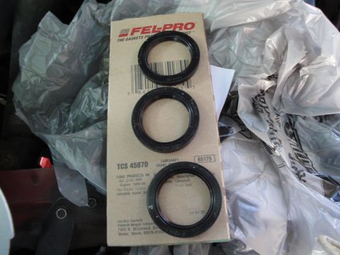 1993 Ford Taurus - A box of Fel-Pro TCS 45870 camshaft seals is shown with three individual seals laid on top.