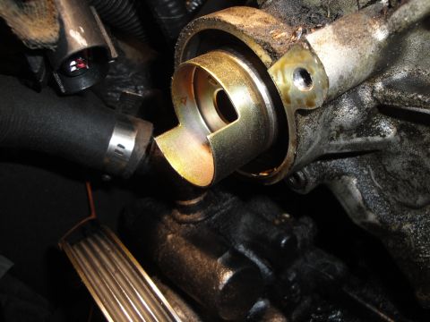 1993 Ford Taurus - A detailed view of an engine part, possibly related to fluid transfer, showing mechanical components and a hose clamp.