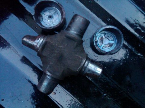 1979 Ford Bronco - A close-up view of a universal joint and its bearing caps, possibly for a vehicle's driveshaft.