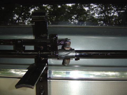 1986 Ford Bronco - Close-up view of a black spare tire carrier mechanism, showing a part number stamped on the metal tube.